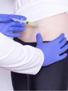 A doctor performing steroid injections on a woman's hip to treat bursitis