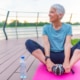 Woman on a yoga mat to relax outdoor. Senior lady prefers healthy lifestyle