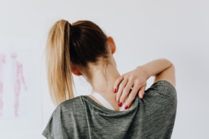woman putting hand on neck- Osteoarthritis treatment
